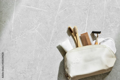 Bilde på lerret Beige fabric toiletry bag with eco-friendly personal care essentials on marble table