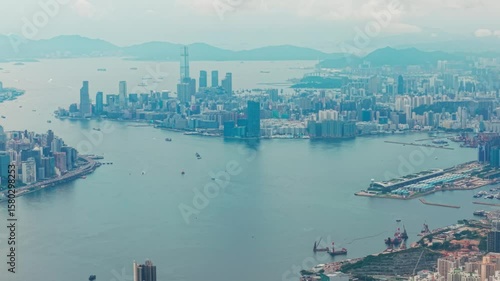 Drone shot of Hong Kong island and Kowloon near Victoria Harbour during a cloudy sunset day with focus on kowloon side
