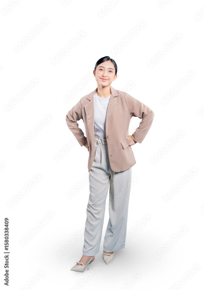 Fototapeta premium Asian businesswoman stands in a power pose with her hands on her hips, smiling at the camera with a look of success, determination, and empowerment.