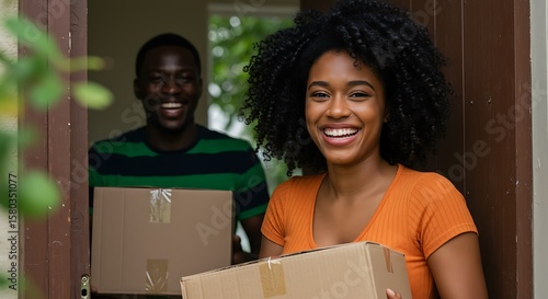 Happy african american couple moving into a new home carrying moving boxes and smiling