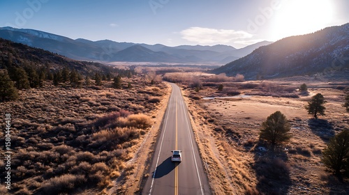 Car Driving on Open Road Through Mountainous Landscape