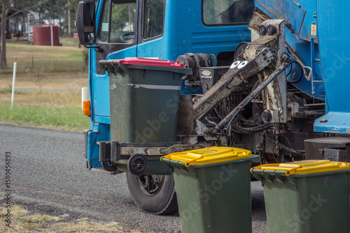 Rubbish from bins being collected by garbage truck