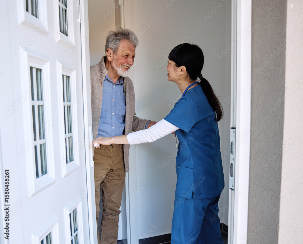 Fototapeta premium Doctor or nurse caregiver woman with senior man at home or nursing home, a caregiver standing on the front door arriving and being welcomed by a senior man