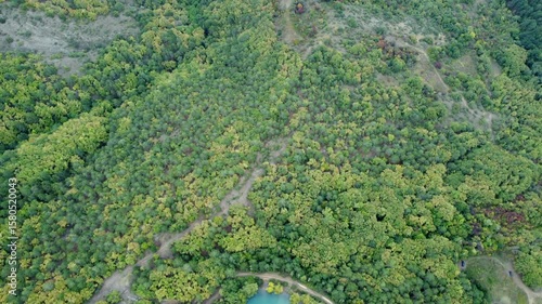 Aerial footage of a green lake with a reflection of clouds on the surface