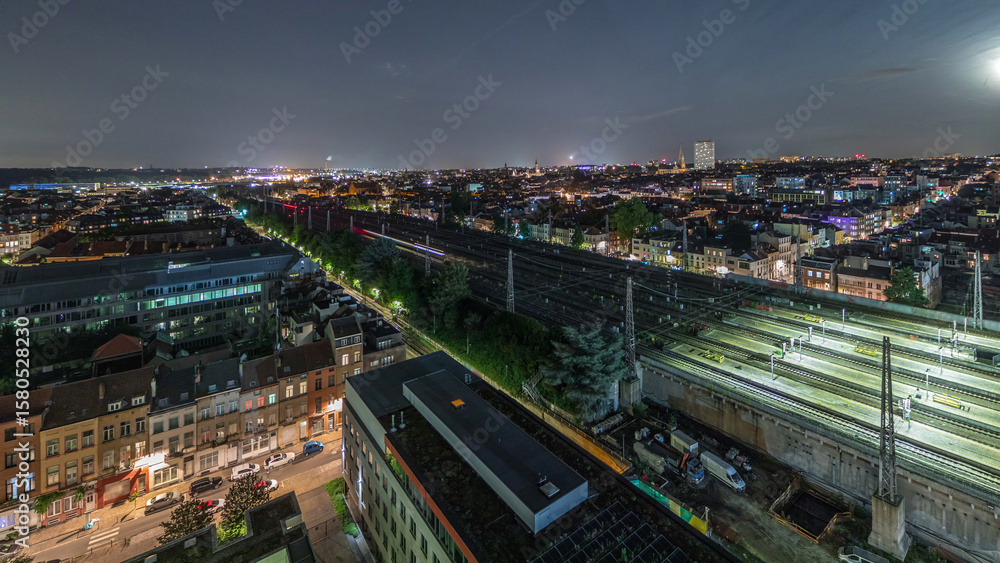 Fototapeta premium Aerial night timelapse of Brussels North station railway tracks with trains arriving and departing. Belgium