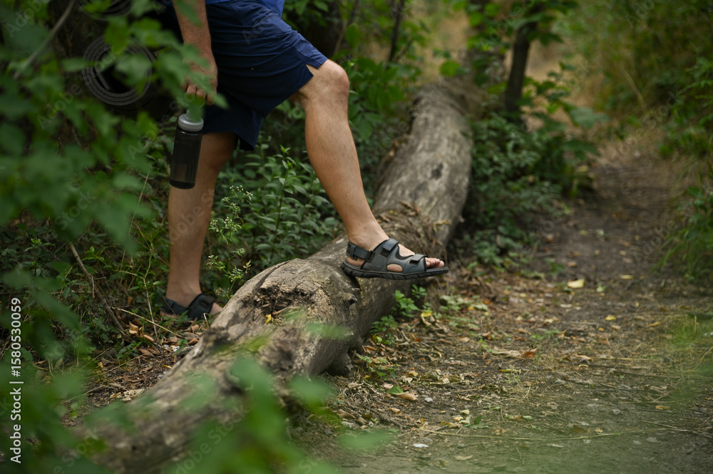 Naklejka premium A man with a backpack walks through the forest and the beach and does sports