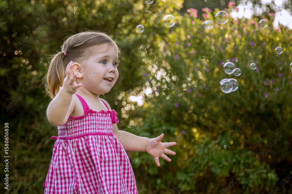 Little girl chasing bubbles outside Little girl chasing bubbles outside