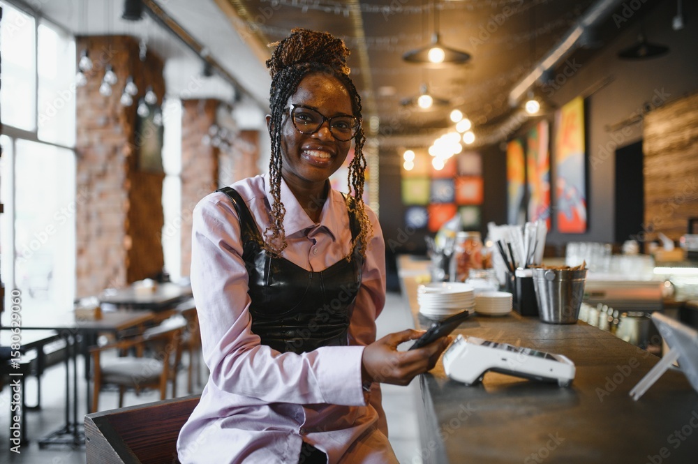 Customer paying with her mobile phone at a small cafe Customer paying with her mobile phone at a small cafe
