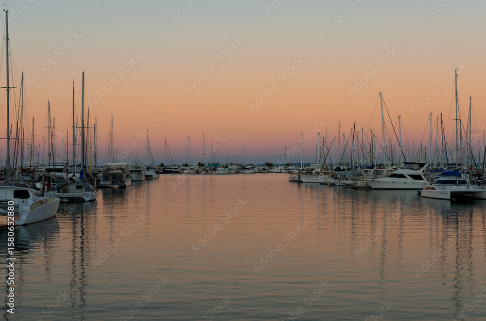 Colourful sunset reflections in a marina with yachts and boats. Colourful sunset reflections in a marina with yachts and boats.