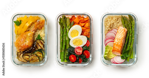 Healthy meal prep ideas, containers, lunchboxes with variety of high protein trendy food, salmon quinoa and avocado, eggs asparagus, kale, sweet potato, chicken, barley and zucchini. White background.