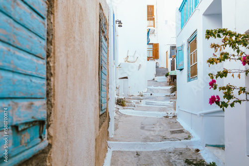 Fototapeta Naklejka Na Ścianę i Meble -  Charming narrow street with stone pavement in Plaka, Milos, Greece