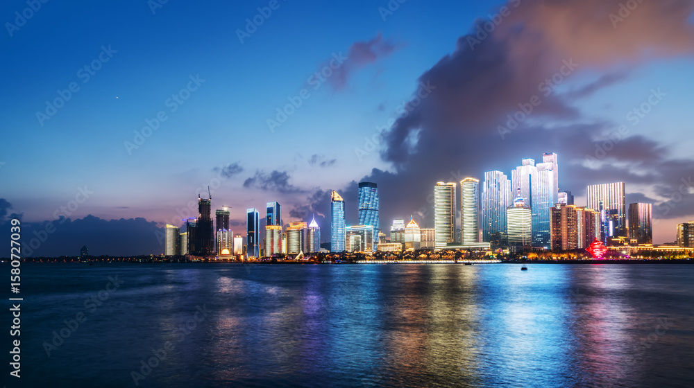 Fototapeta premium City skyline at dusk with modern buildings reflecting on water