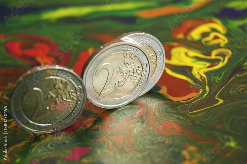 Proof 2 euro coins on a mottled abstract surface.