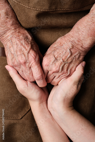 Young woman holding senior woman hands. Hands of old and young woman. The granddaughter comforts the grandmother. Concept of support and care, love, warmth,, Mother's day, help, donate.
