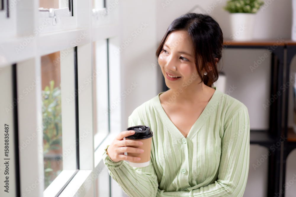 Portrait young asian woman relax and enjoyment with drinking coffee by the window in living room at home, woman smiling with happiness and comfortable drinking beverage at home, lifestyle and leisure. Portrait young asian woman relax and enjoyment with drinking coffee by the window in living room at home, woman smiling with happiness and comfortable drinking beverage at home, lifestyle and leisure.