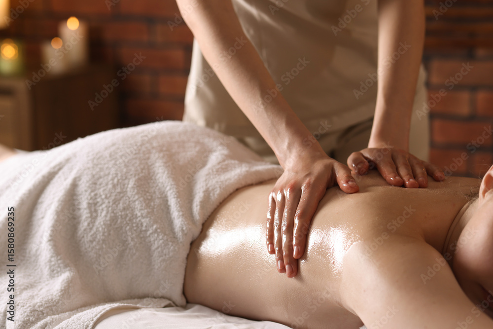 Fototapeta premium Woman receiving back massage with oil in spa salon, closeup