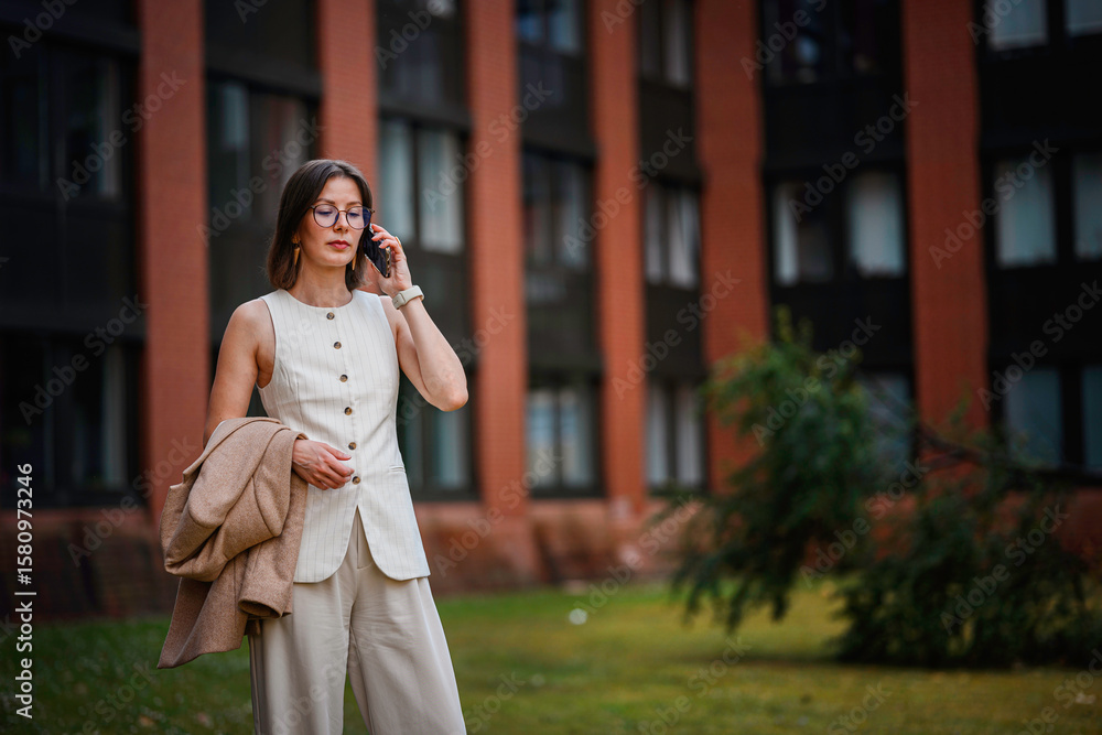 Obraz premium Businesswoman Talking on Phone Near Office Building