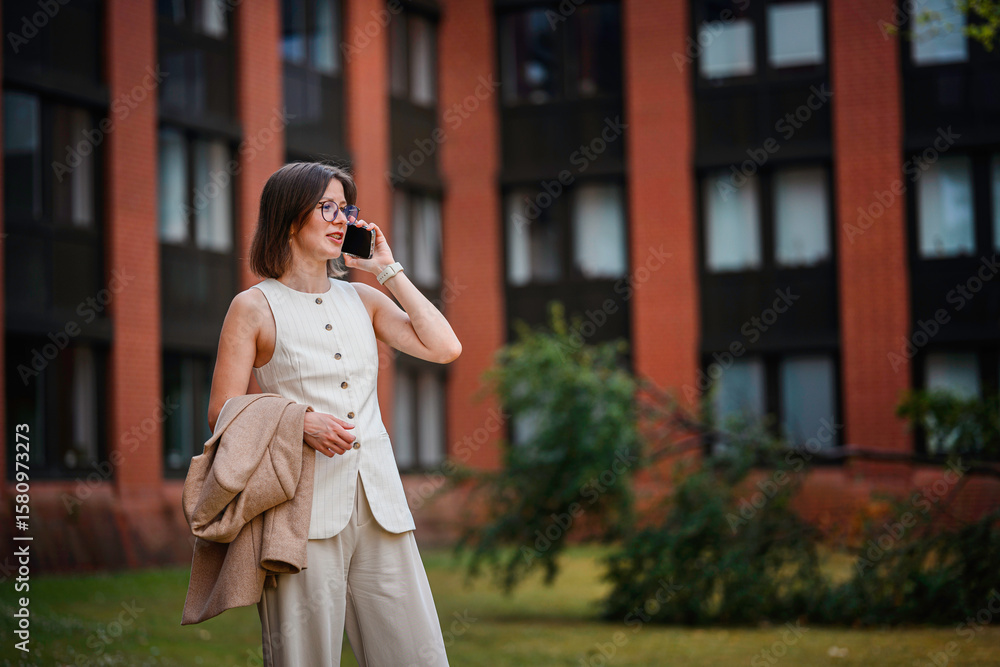 Obraz premium Businesswoman Talking on Phone Near Office Building