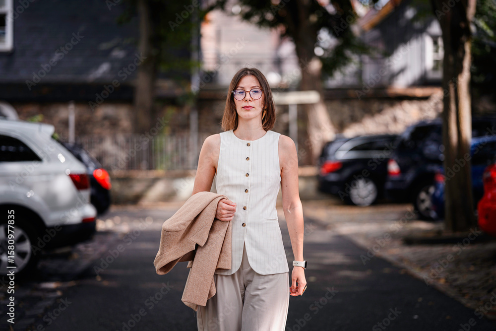 Fototapeta premium Confident Woman Walking Outdoors in Business Attire