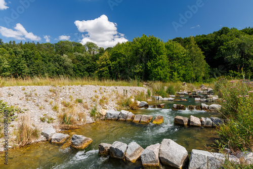 Artificial fish ladder in a river stream, surrounded by forest and blue sky, illustrating ecological river restoration and sustainable water infrastructure