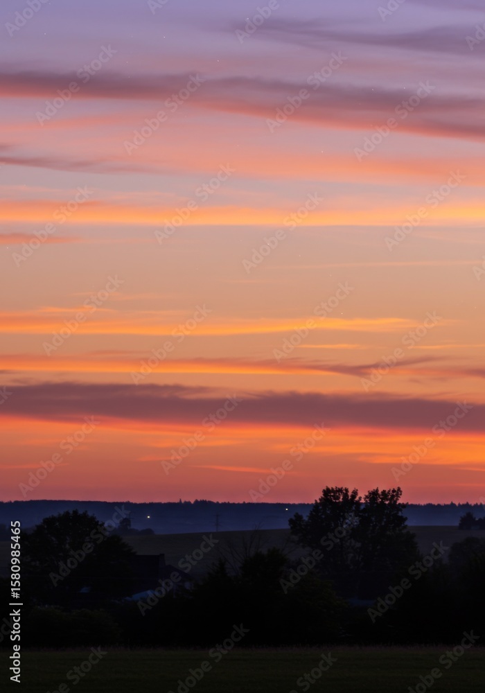 Fototapeta premium Vibrant Sunset Landscape with Orange And Purple Clouds