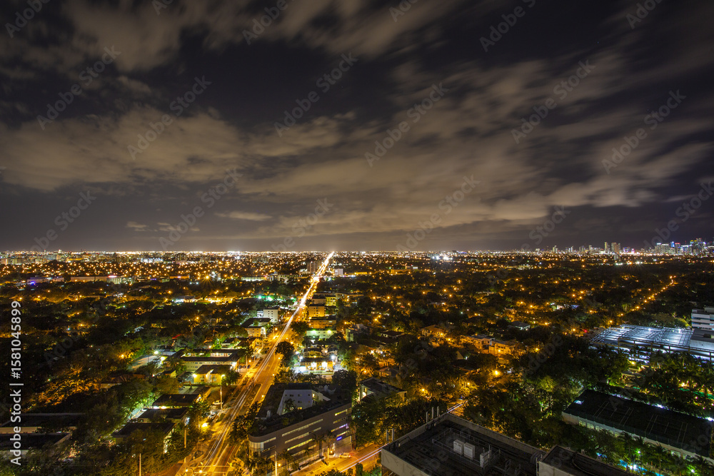 Aerial view of a vibrant city bathed in golden lights under a cloudy night sky, Miami, Florida, United States. Aerial view of a vibrant city bathed in golden lights under a cloudy night sky, Miami, Florida, United States.