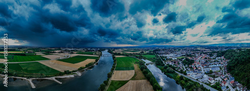 Fotografie Beeindruckende Landschaft über dem Fluss bei Dämmerung mit Gewitterwolken und gr