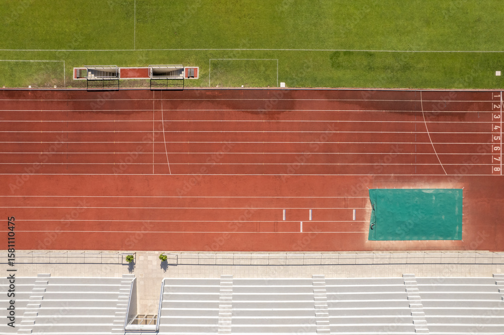 Fototapeta premium Aerial view of the Manuela Machado Municipal Stadium in Viana do Castelo, Portugal. Eight empty red tracks for running sports with tartan track of synthetic rubber on the athletic stadium.