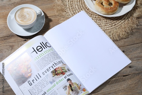 Open magazine, pretzels and coffee on wooden background, closeup. Mockup for design