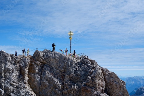 Gipfelkreuz der Zugspitze mit Wanderern im Sommer
