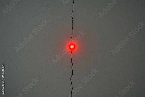 Red Laser Dot Aligned on Wall Crack – Symbol of Targeting Tension and Precision

