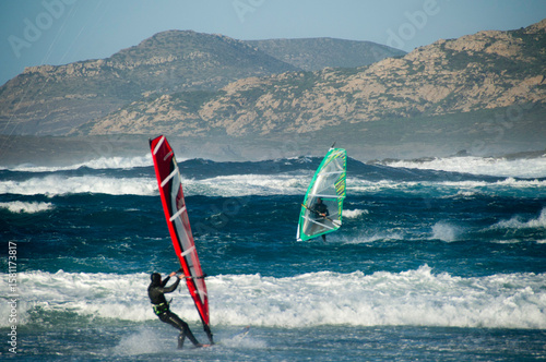 windsurfer in action, Panned shot of a windsurfer sailing high speed, unrecognizable person. Alghero, Sardinia, Italy, Windsurf sul litorale di Stintino, spiaggia de la pelosa, SS. Sardegna. Italia