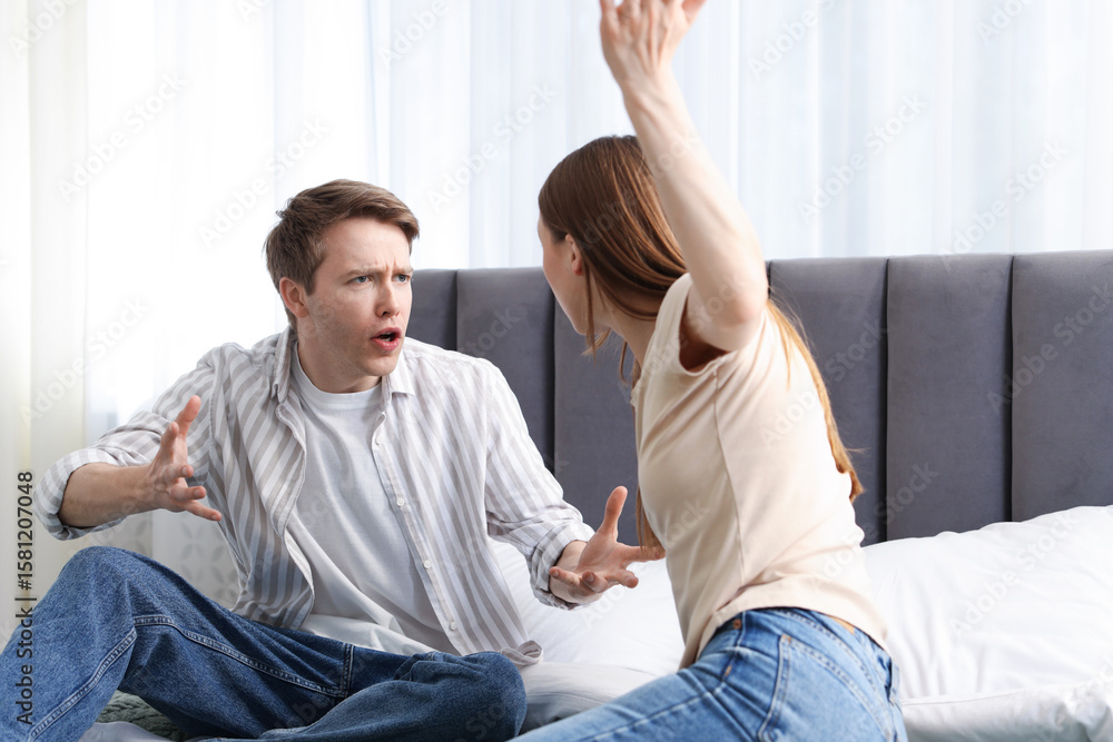 Fototapeta premium Woman and man fighting on bed at home