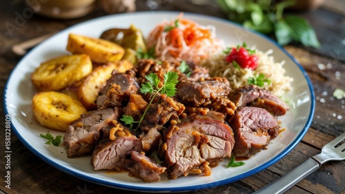 A plate of Grillot, a popular Haitian dish consisting of marinated pieces of roast pork served with a side dish of fried bananas, a portion of piclise (spicy pickled vegetables) and rice.