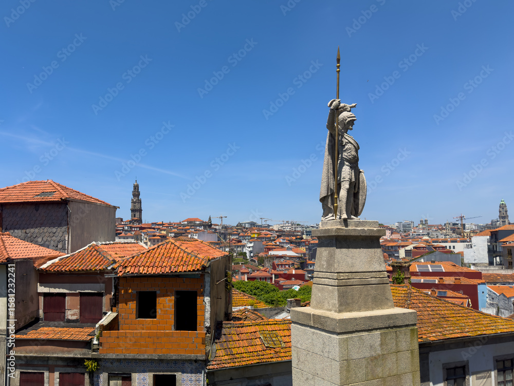 Obraz premium Statue in Porto, Portugal, medieval warrior with spear overlooking cityscape, red tiled rooftops,