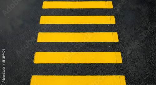 High-angle view of yellow pedestrian zebra crossing on asphalt road surface for road safety concept crossing mark