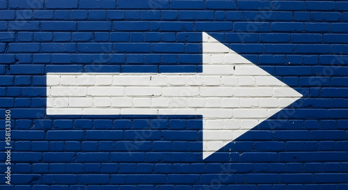Simple directions painted white arrow on blue brick wall guidance system art