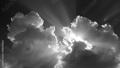 Fototapeta Naklejka Na Ścianę i Meble -  Dramatic sun rays bursting through dark storm clouds in black and white
