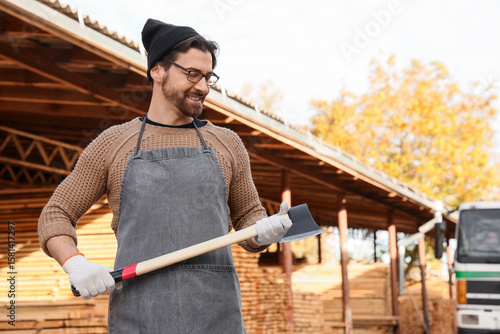 Male carpenter with axe at ...