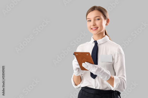 Young waitress writing in c...