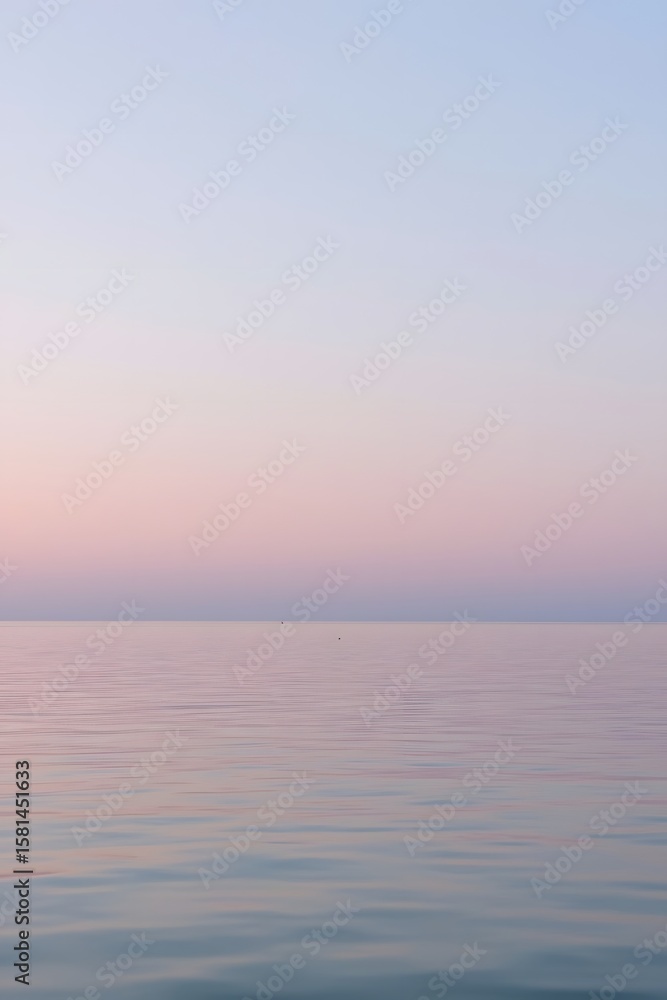 Obraz premium Calm pastel pink and blue horizon over a smooth sea during sunset, creating a serene and minimalistic atmosphere perfect for backgrounds, wellness, relaxation, and nature-themed designs