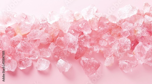 Pink crystals arranged in a horizontal line against a pale pink background