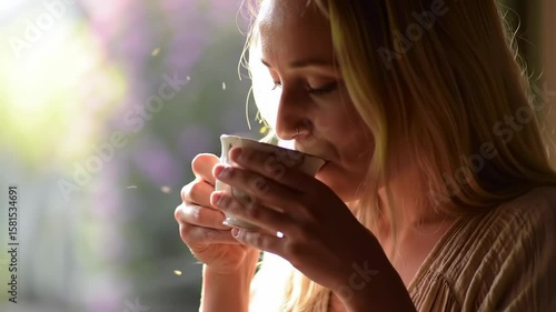 Woman sipping a warm drink in natural light