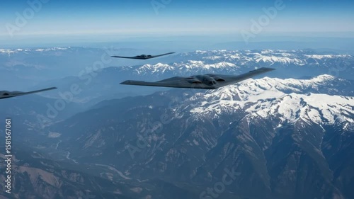 Aerial view of b two spirit bombers flying in formation over snow capped mountains on a clear day