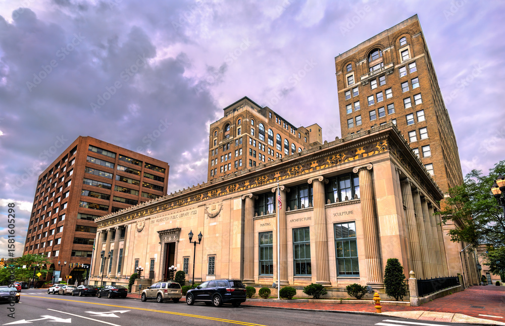 Obraz premium Elegant exterior view of the Wilmington Public Library in Delaware, USA, showcasing its neoclassical architecture with grand columns, detailed stonework, and arched windows in a civic urban setting.