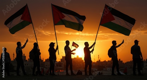 People holding Palestinian flags against a vibrant orange sunset, symbolizing national pride and resilience