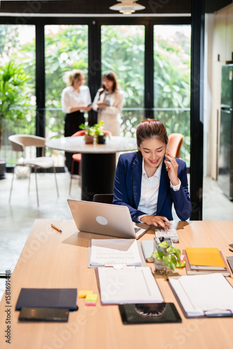 businesswoman working by phone and laptop in modern office .
