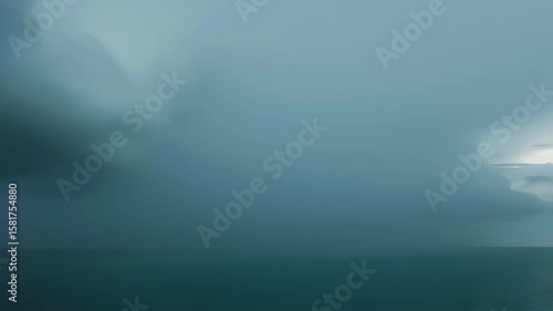 Dark thunderstorm clouds unleashing cascading rain onto a restless ocean beneath a brooding sky, dramatic seascape capturing nature’s raw power with churning waves and moody lighting on the open sea