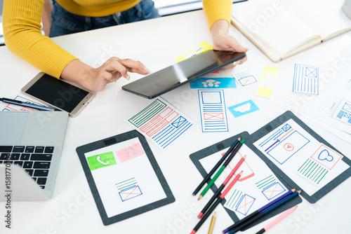 Foto Website designer, Creative planning phone app development template layout framework wireframe design, User experience concept, Young asian UX designer working on smartphone application at office