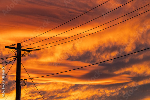 Electricity pole and wires with red sky sunset